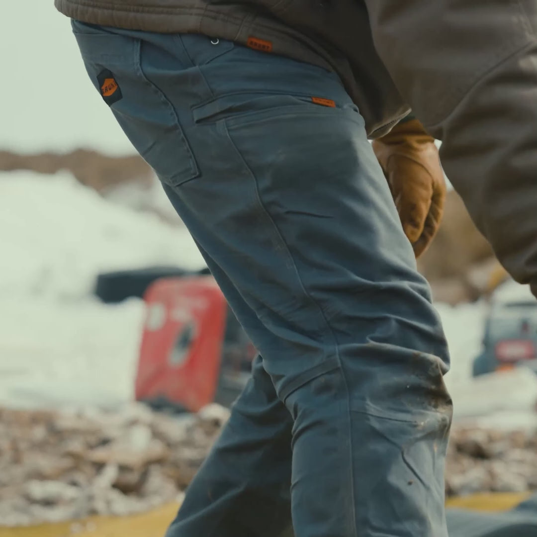 Man on jobsite wearing BRUNT water resistant double-knee torra hd work pant in charcoal