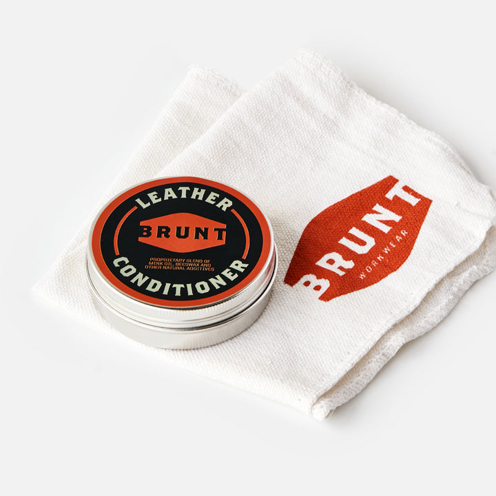 View 1 container of BRUNT leather work boot conditioner and shop rag with BRUNT logo